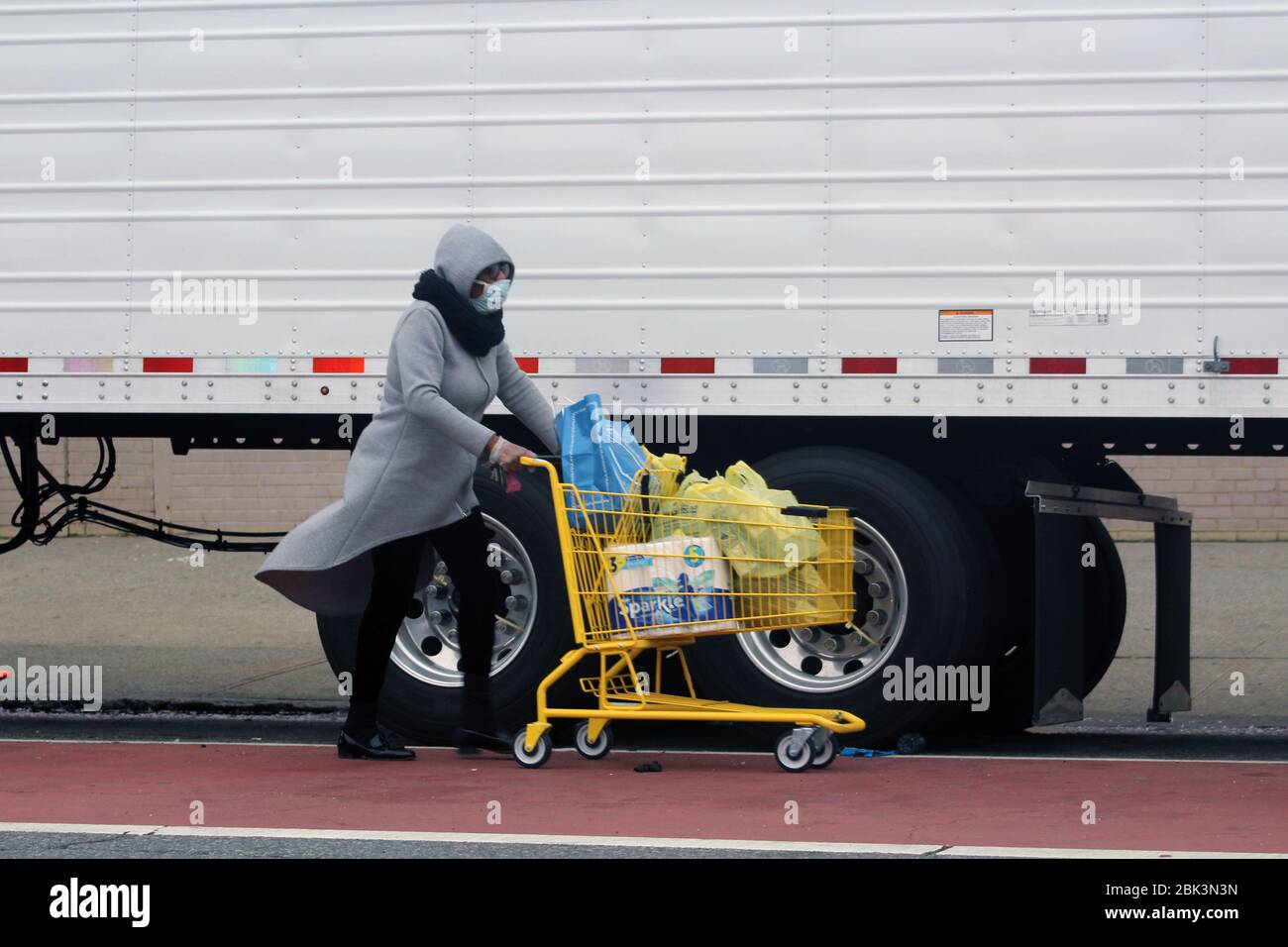 New York, New York, USA. 30th Apr, 2020. This employee masked face pushes a shopping cart containing cleaning products along a refrigerated truck to the Andrew T. Cleckley Funeral Home in Brooklyn where bodies non properly cared are removed. 60 corpses were stored in 4 rented vehiciles lining the street nearby stores. Neighbors reported a foul smell still persistent and fluids dripping from the trucks. Some remains were also found lying on the facilityÃ¢â‚¬â„¢s floor. The funeral home was overwhelmed by COVID-19 deaths in New York. Credit: Marie Le Ble/ZUMA Wire/Alamy Live News Stock Photo