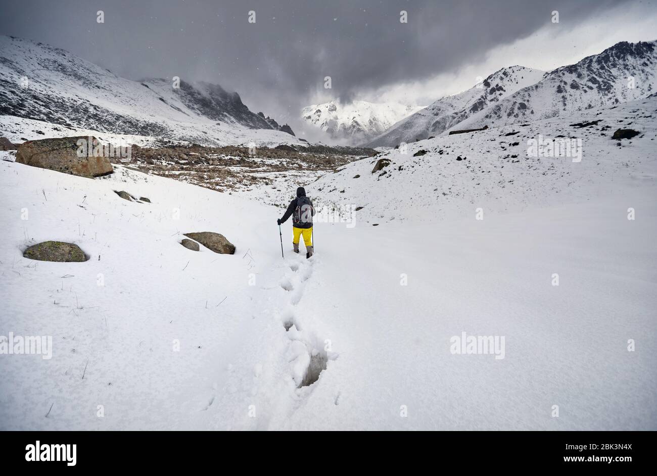 Tourist in the snow path at beautiful overcast sky background. Outdoor climbing concept. Stock Photo