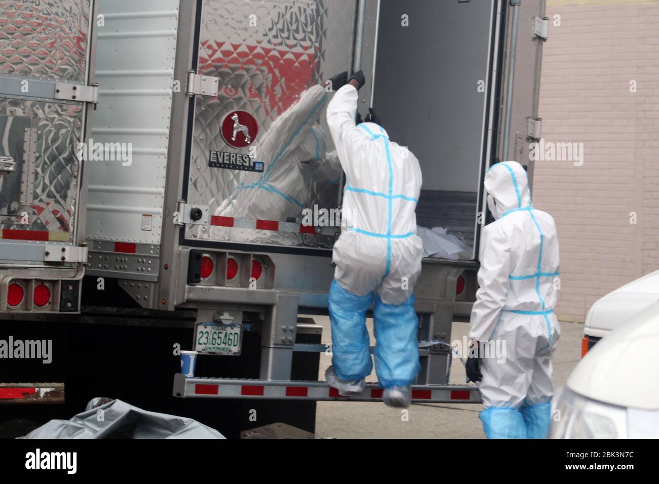 New York, New York, USA. 30th Apr, 2020. One of these 2 workers, dressed in a hazmat, gets off one of the big refrigerated trucks where bodies have been disposed next to the Andrew T. Cleckley Funeral Home in Brooklyn whose corpses not properly cared have been removed. 60 bodies were stored in 4 non-refregerated vehiciles lining the street nearby stores. Neighbors reported a foul smell still persistent and fluids dripping from the trucks. The funeral home was overwhelmed by COVID-19 deaths, waiting for weeks for cremations in New York. Credit: Marie Le Ble/ZUMA Wire/Alamy Live News Stock Photo