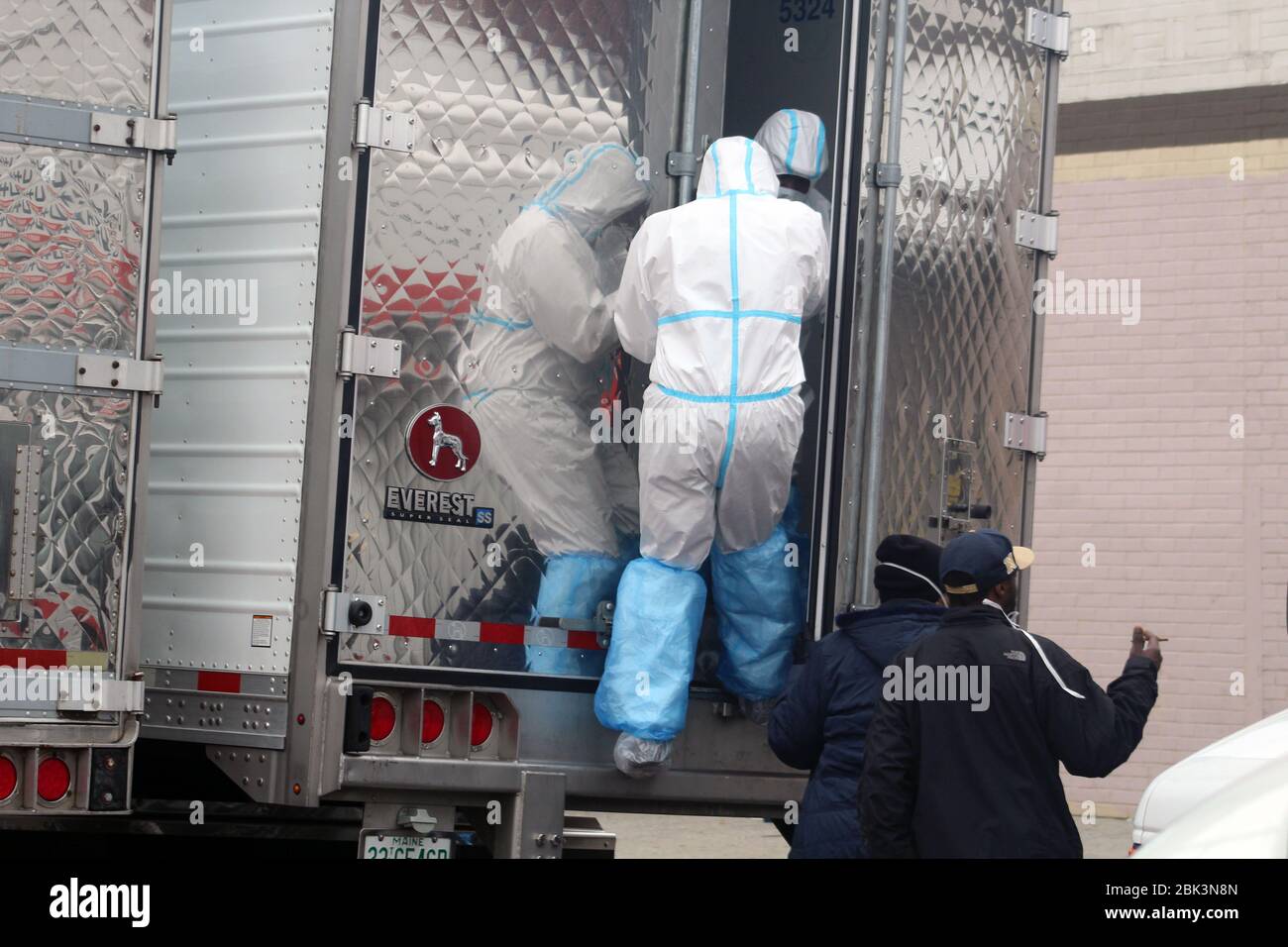 New York, New York, USA. 30th Apr, 2020. This man, dressed in a hazmat, climbs in one of the big refrigerated trucks where bodies have been disposed next to the Andrew T. Cleckley Funeral Home in Brooklyn whose corpses not properly cared have been removed. 60 bodies were stored in 4 non-refregerated vehiciles lining the street nearby stores. Neighbors reported a foul smell still persistent and fluids dripping from the trucks. The funeral home was overwhelmed by COVID-19 deaths, waiting for weeks for cremations in New York. Credit: Marie Le Ble/ZUMA Wire/Alamy Live News Stock Photo