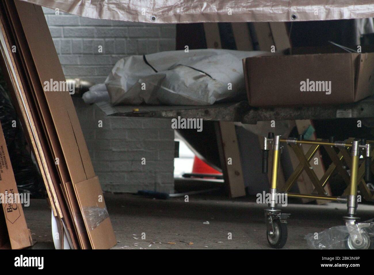 April 30, 2020, New York, New York, USA: A stained white bag containing a body have been placed on the hoist of a refrigerated truck, about to be removed from the Andrew T. Cleckley Funeral Home in Brooklyn. Cardboard coffins and a stretcher are next to it. 60 bodies were stored in 4 non-refregerated vehiciles lining the street nearby stores. Neighbors reported a foul smell still persistent and fluids dripping from the trucks. Some remains were also found lying on the facilityÃ¢â‚¬â„¢s floor. The funeral home was overwhelmed by COVID-19 deaths in New York. (Credit Image: © Marie Le Ble/ZUMA Wi Stock Photo