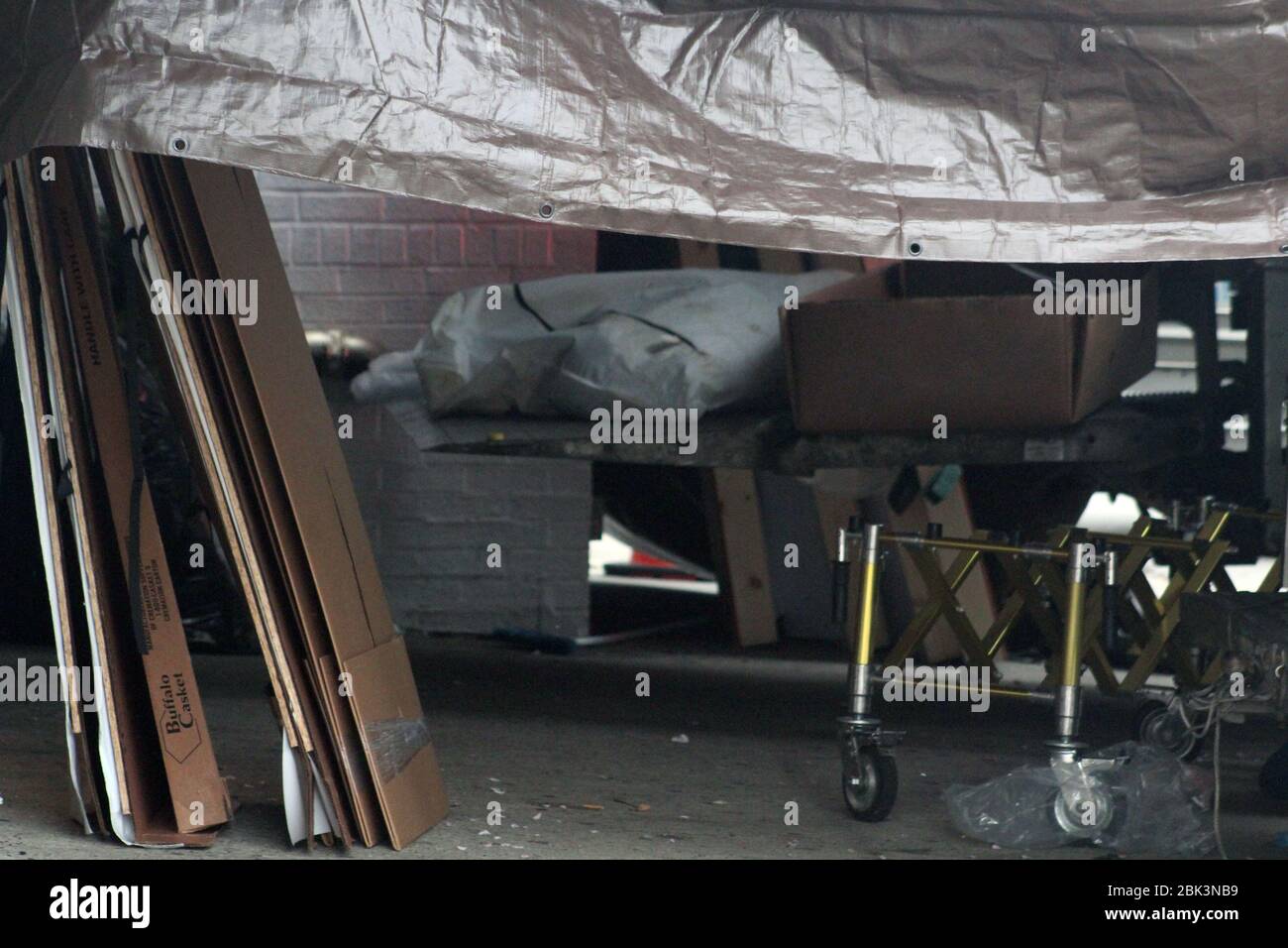 April 30, 2020, New York, New York, USA: A stained white bag containing a body have been placed on the hoist of a refrigerated truck, about to be removed from the Andrew T. Cleckley Funeral Home in Brooklyn. Cardboard coffins and a stretcher are next to it. 60 bodies were stored in 4 non-refregerated vehiciles lining the street nearby stores. Neighbors reported a foul smell still persistent and fluids dripping from the trucks. Some remains were also found lying on the facilityÃ¢â‚¬â„¢s floor. The funeral home was overwhelmed by COVID-19 deaths in New York. (Credit Image: © Marie Le Ble/ZUMA Wi Stock Photo