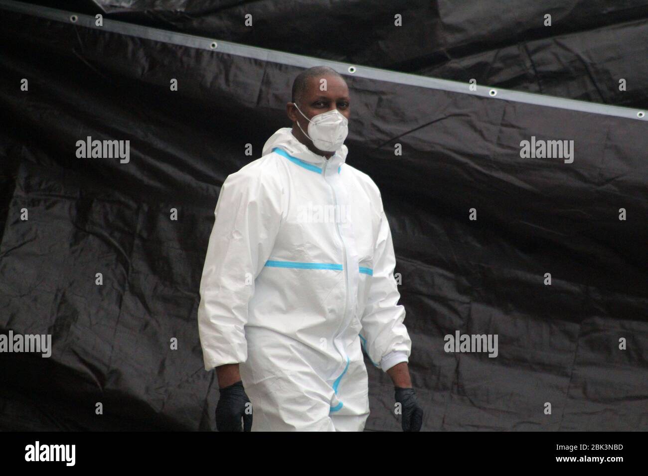 New York, New York, USA. 30th Apr, 2020. A worker, dressed in a hazmat and masked face, goes along a brown tarp set up in front of the Andrew T. Cleckley Funeral Home in Brooklyn where bodies non properly cared are removed. 60 corpses were stored in 4 rented vehiciles lining the street along stores. Neighbors reported a foul smell and fluids dripping from the trucks. Some remains were also found lying on the facilityÃ¢â‚¬â„¢s floor. In New York City alone, there have been almost 13,000 COVID-19 deaths. Credit: Marie Le Ble/ZUMA Wire/Alamy Live News Stock Photo
