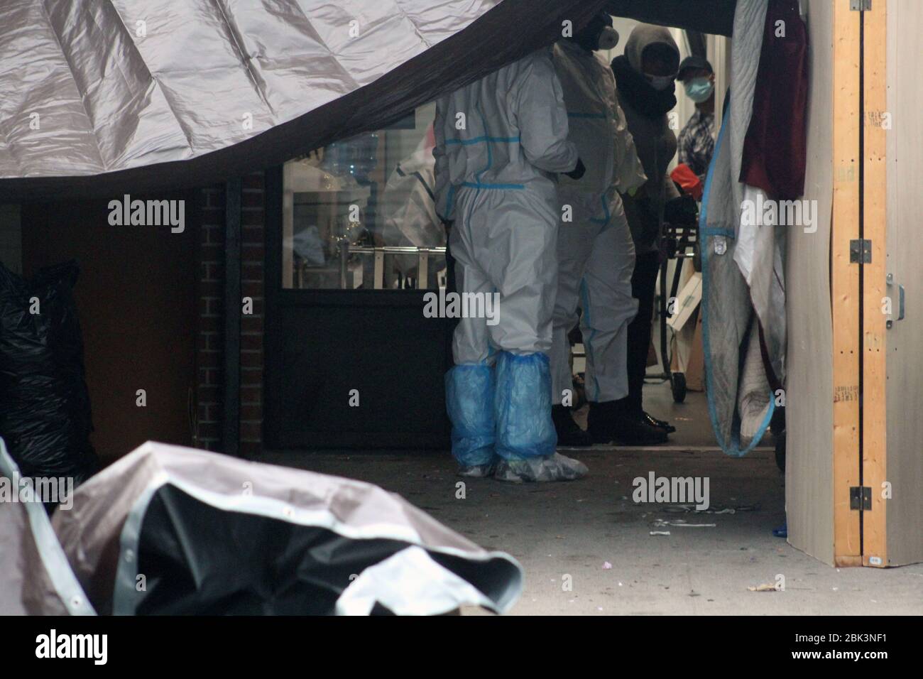 New York, New York, USA. 30th Apr, 2020. Workers dressed in a hazmat and employees masked faces stand at the entrance to the Andrew T. Cleckley Funeral Home in Brooklyn where bodies non properly cared have been removed. 60 corpses were stored in 4 non-refregerated rented trucks lining the street nearby stores. Neighbors reported a foul smell still persistent and fluids dripping from the trucks. Some remains were also found lying on the facilityÃ¢â‚¬â„¢s floor. The funeral home was overwhelmed by COVID-19 deaths, waiting for weeks for cremations. Credit: Marie Le Ble/ZUMA Wire/Alamy Live News Stock Photo