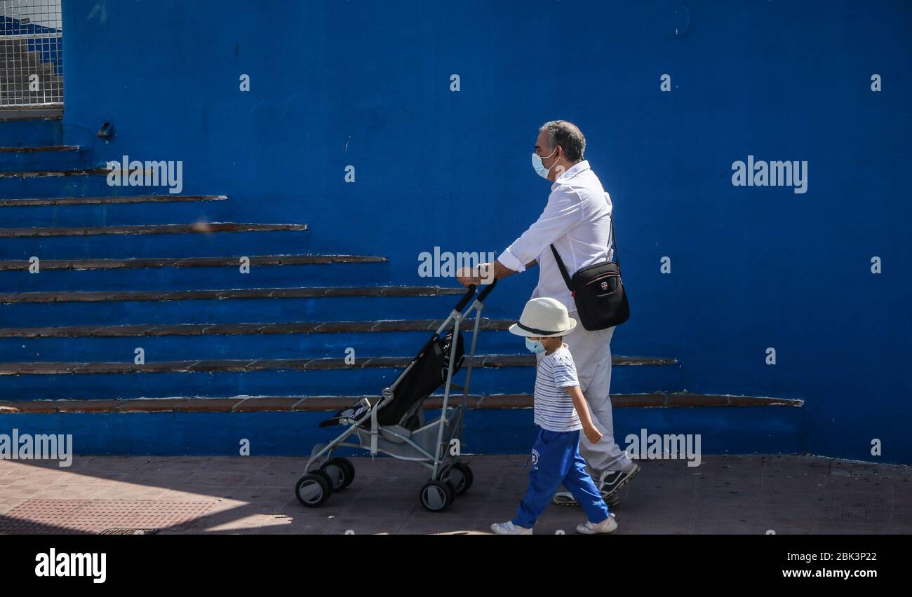 May 1, 2020: May 1, 2020 (Malaga)Father walks with his son on the seafront of Benalmadena Costa with mask due to the crisis of the Coronavirus Credit: Lorenzo Carnero/ZUMA Wire/Alamy Live News Stock Photo