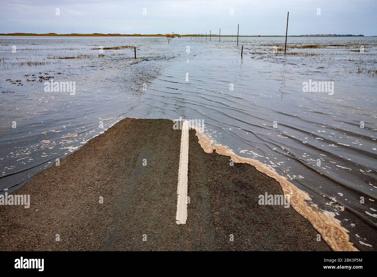 The causeway onto Lindisfarne island as it starts to flood at high tide, Northumberland, England Stock Photo