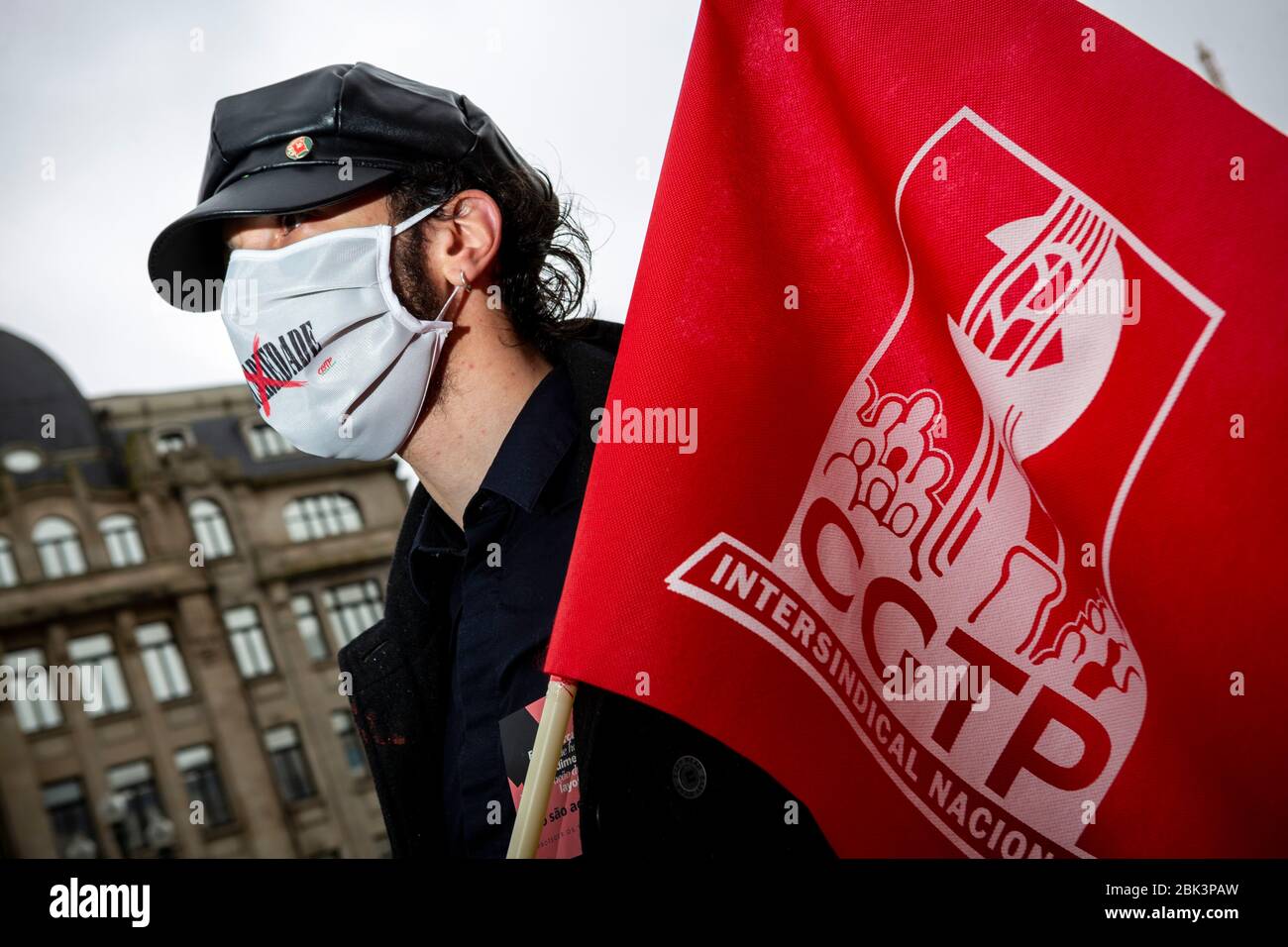 A man stages a silent protest while practicing social distancing to mark Labor Day in Porto, Portugal. Workers were forced to scale back May Day rallies around the world on May 1, 2020, because of coronavirus lockdowns, although some pushed on with online events and others hit the streets in face masks. Stock Photo