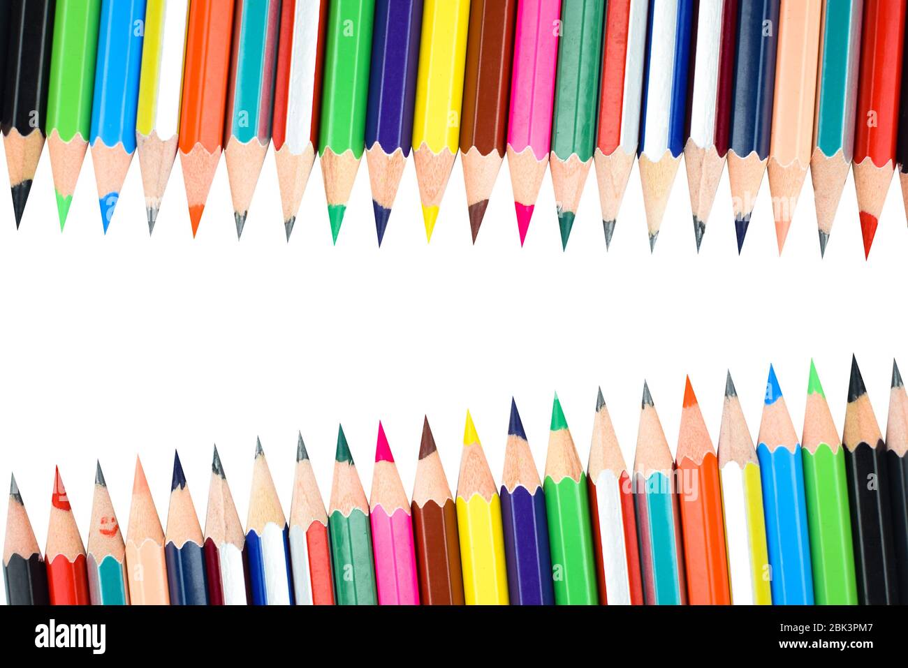 Different rows of different color pencil crayons placed on a white ...