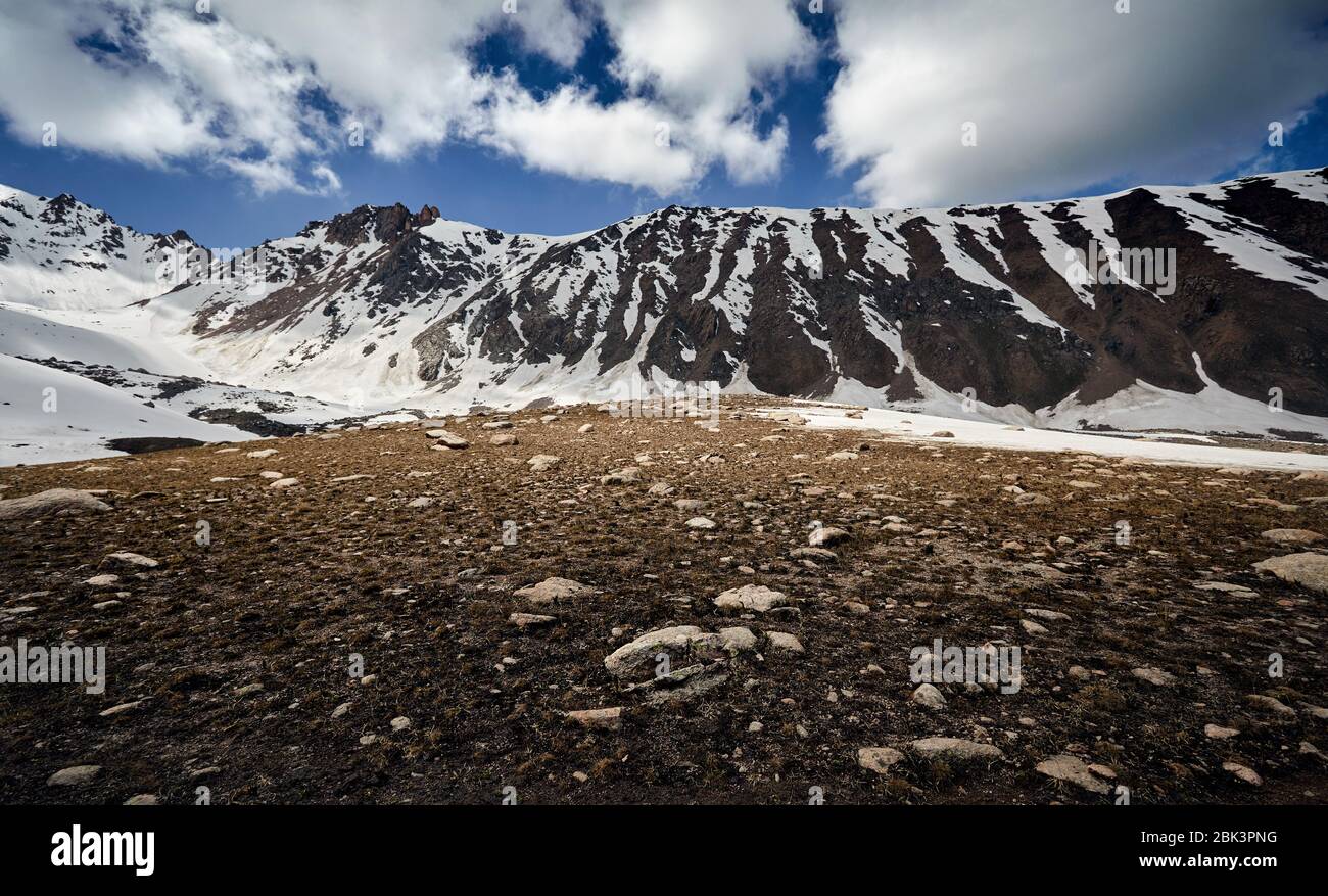 Landscape of snow mountain valley against cloudy sky in Kazakhstan Stock Photo