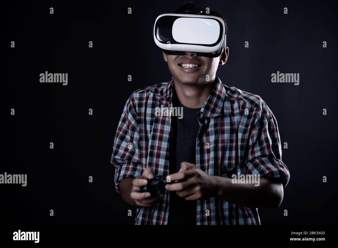 Student man wearing virtual reality goggles in studio,Smartphone using with VR headset. Stock Photo