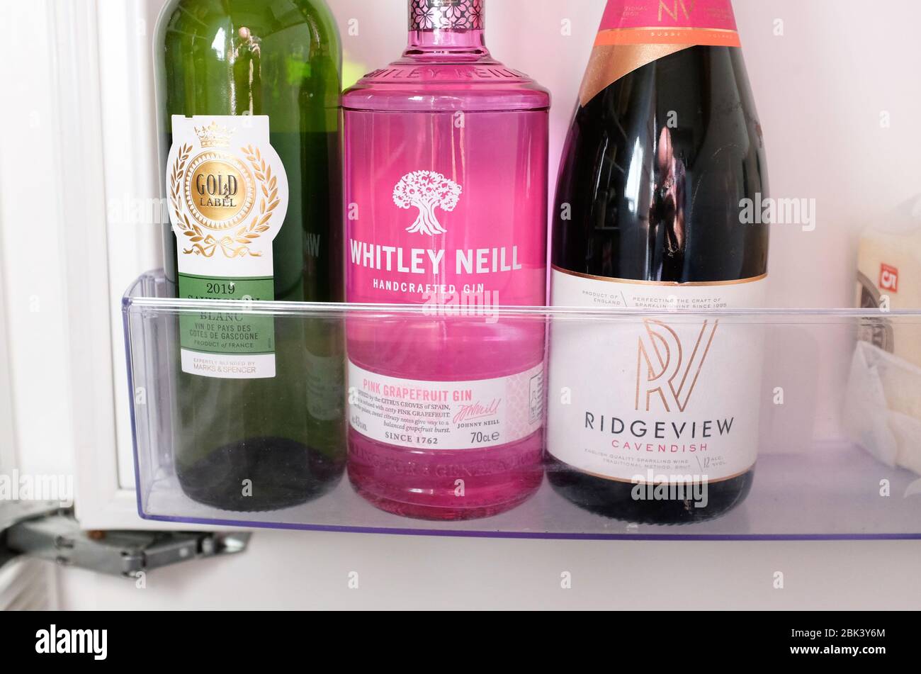 Bottles of wine gin and Ridgeview English Sparkling wine in a cold fridge Stock Photo