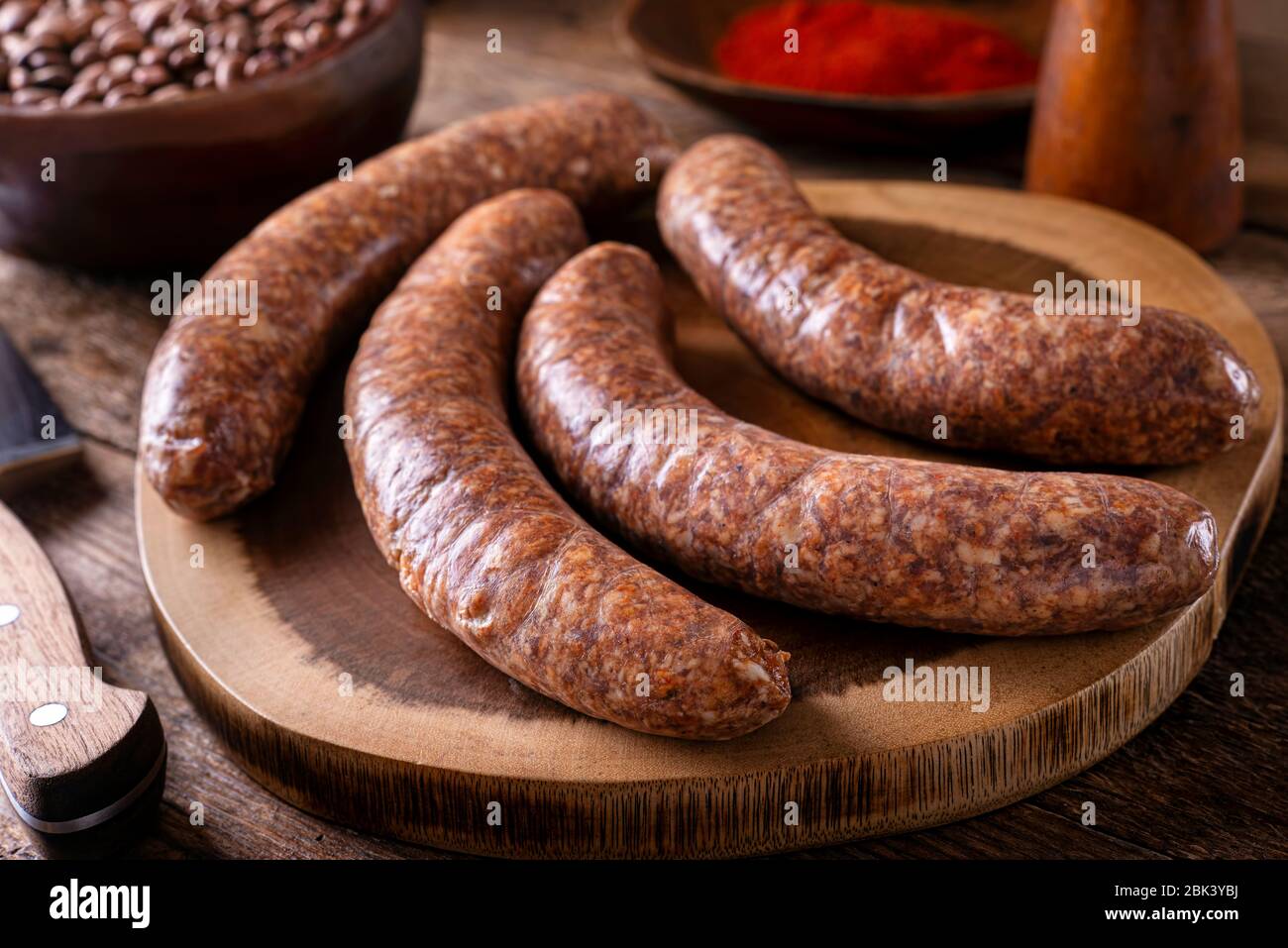 Freshly made rustic sausages on a wood cutting board. Stock Photo