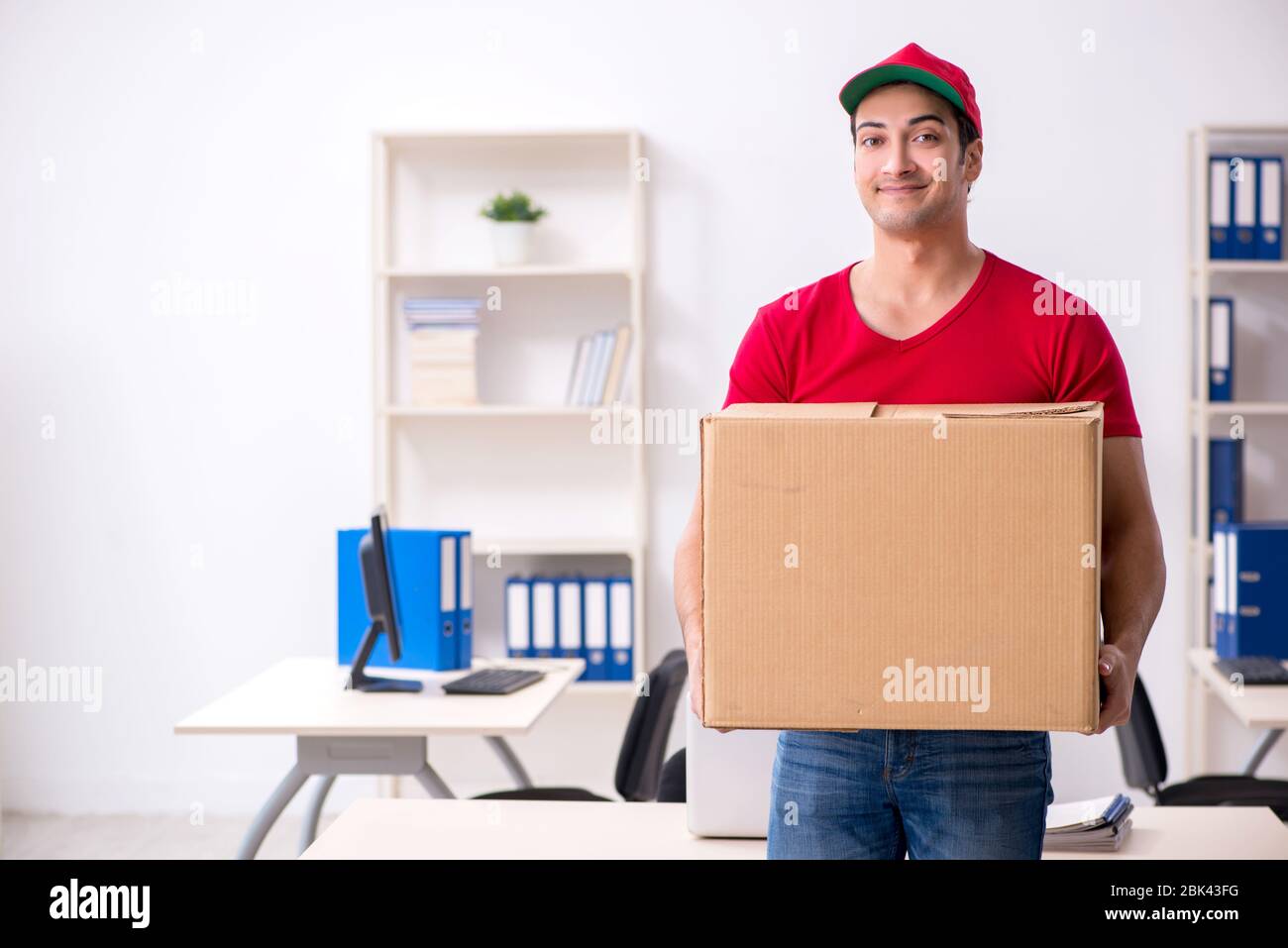 Young courier delivering postbox to the office Stock Photo Alamy