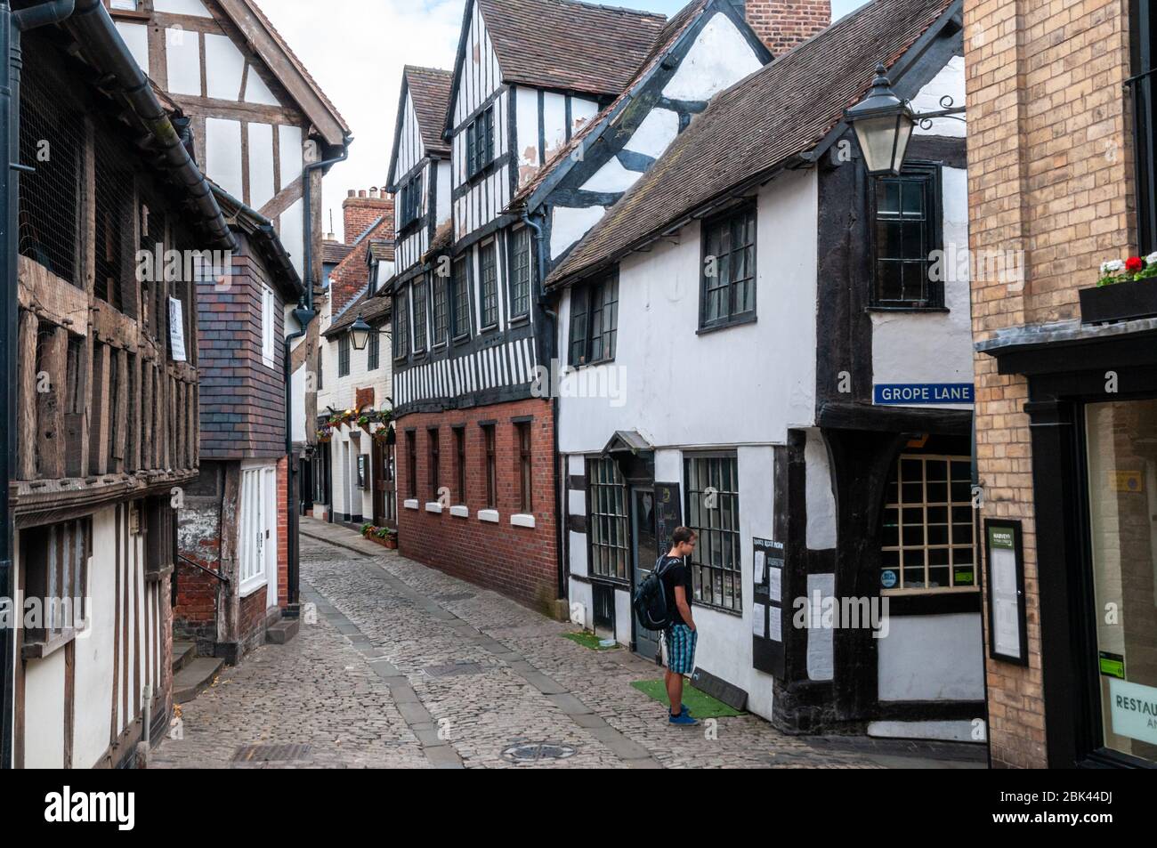 A young man studies the menu of Isaac's Keep restaurant on the corner of Fish Street and Grope Lane in old, historic town centre of Shrewsbury, UK. Stock Photo