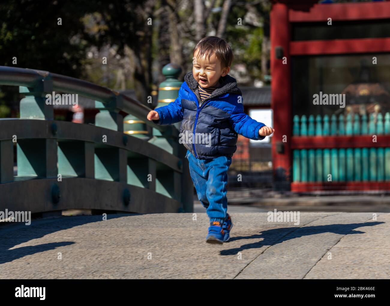 Child Running Across Bridge at Nezu Shrine, Tokyo Stock Photo