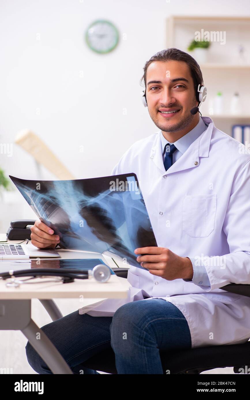 Photo Session Doctor Young male doctor listening to patient during telemedicine session ...