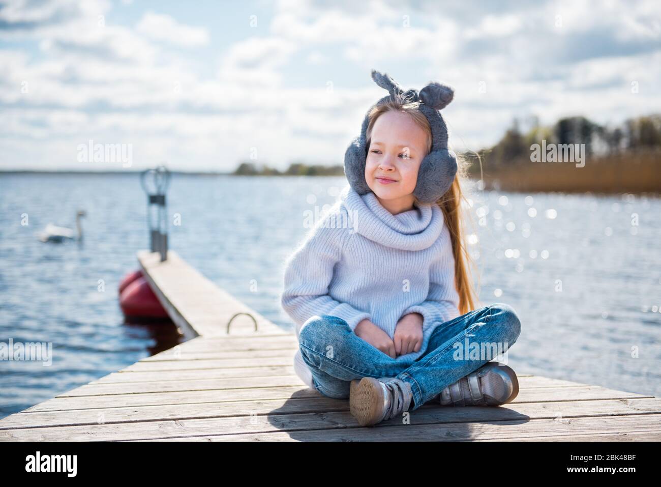 Little girl resting sitting by the river in spring nature Stock Photo ...
