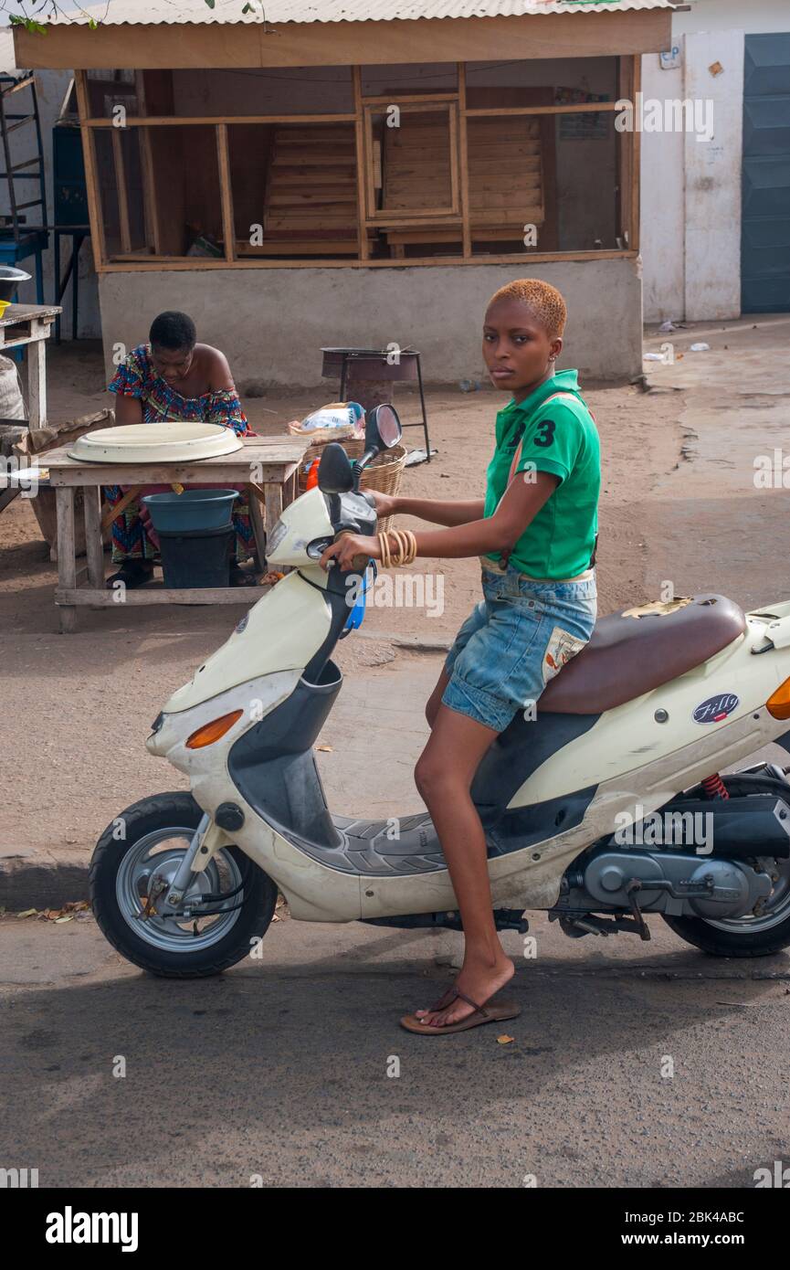 A street scene with a woman on a motor scooter in Lome, the capital city of  Togo in West Africa Stock Photo - Alamy