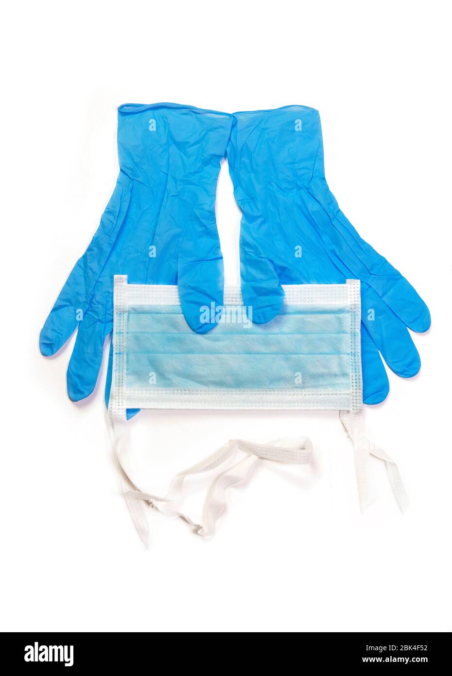 personal protective equipment blue latex gloves with a face mask , that you might wear to portect you from a virus , isolated on a white background Stock Photo