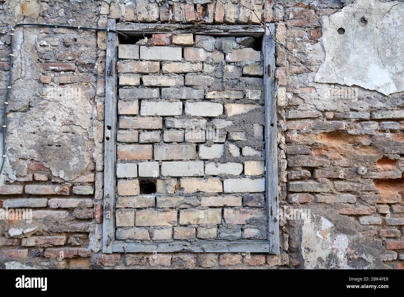 Window is covered with bricks in old brick wall Stock Photo