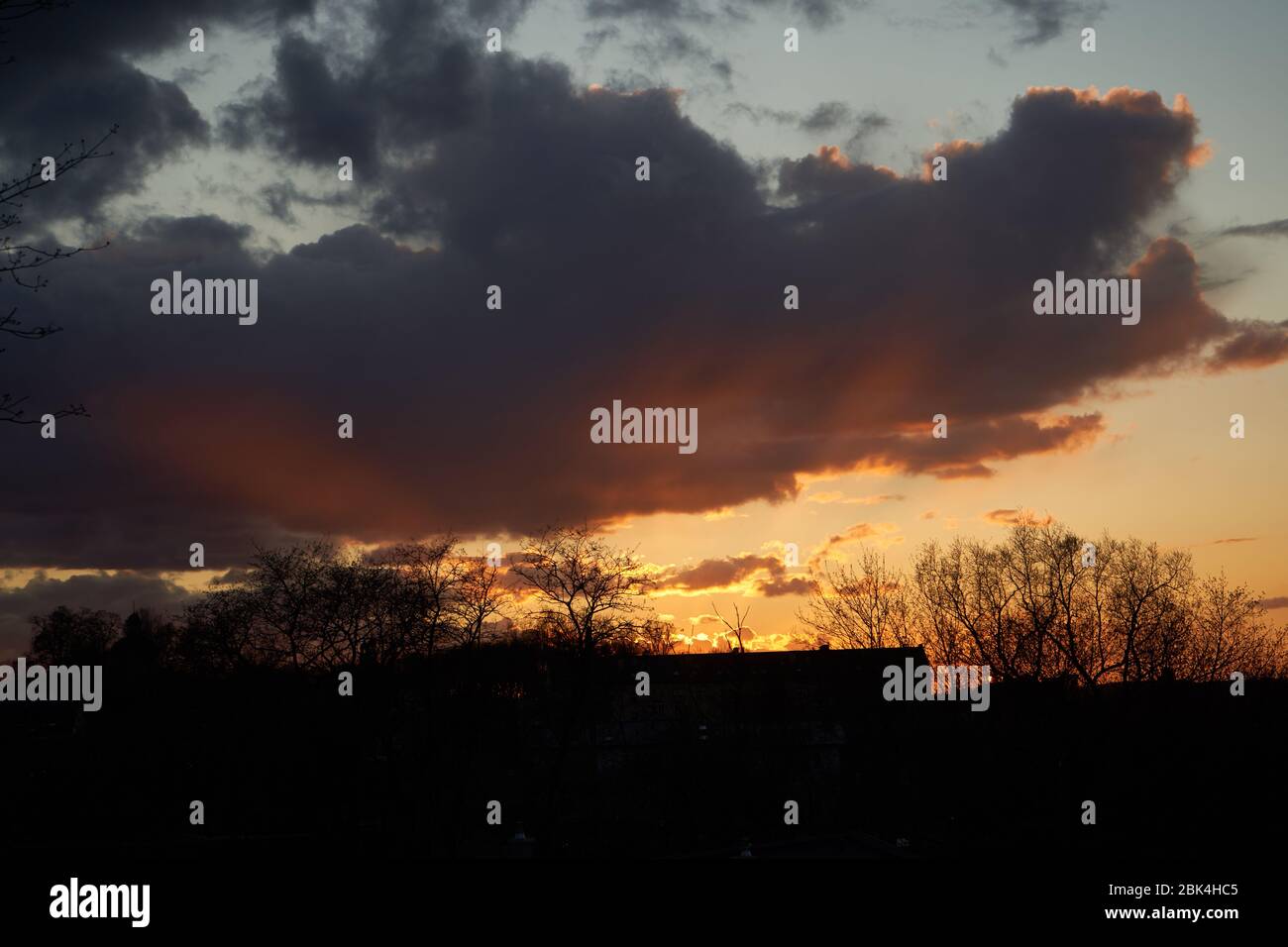 Sunset in the dark clouds at spring time Stock Photo