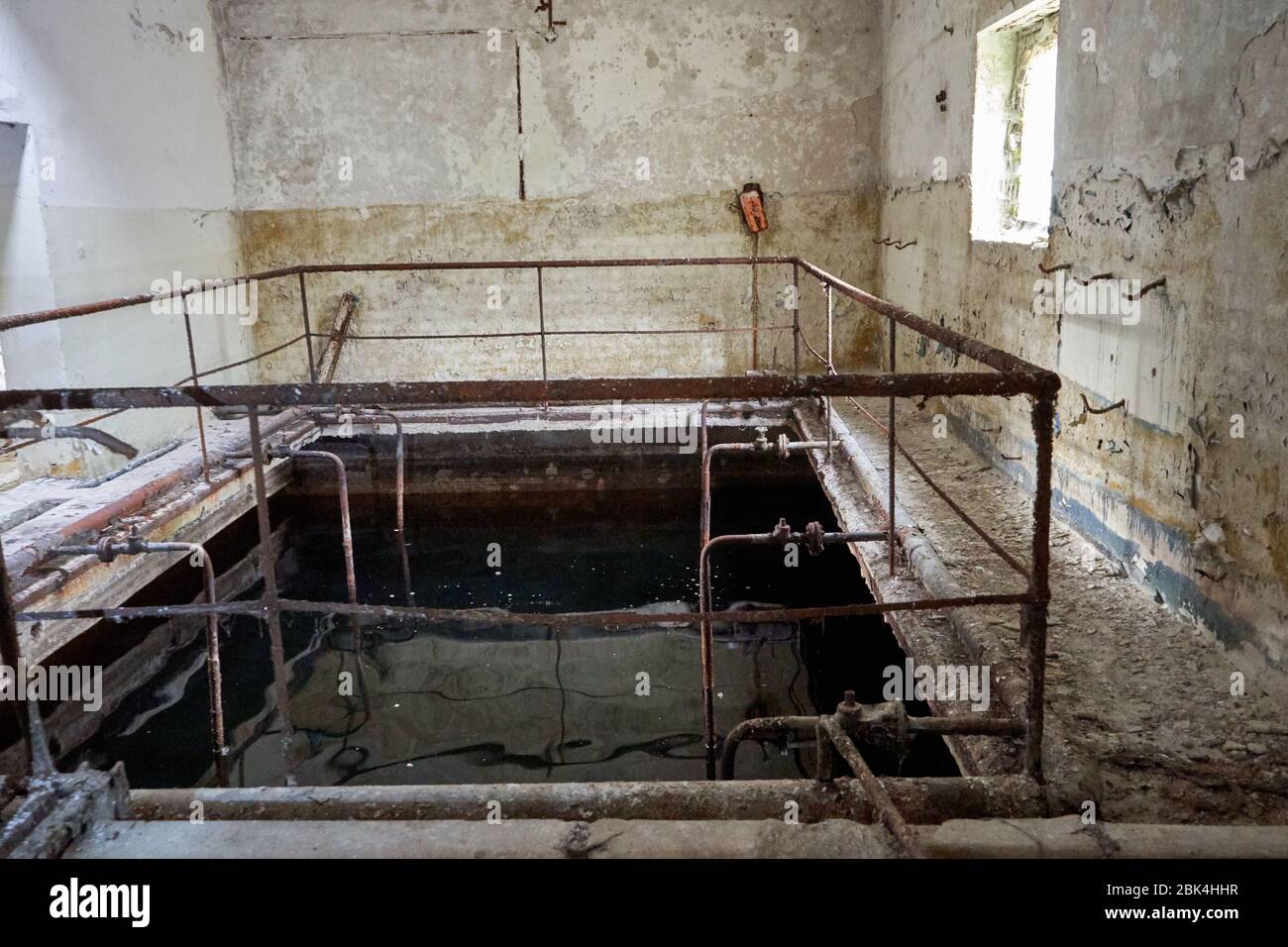 Abandoned factory building with water pool inside Stock Photo