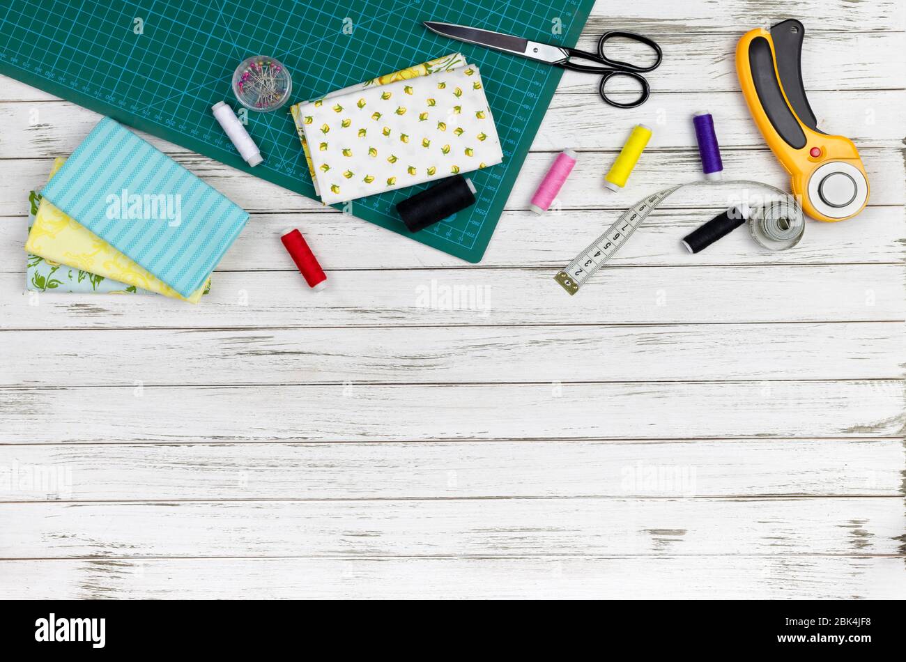 there are quilting, embroidery and sewing tools on the table. patchwork knife, scissors, lined cutting mat, self-locking, threads, measuring tape, flo Stock Photo