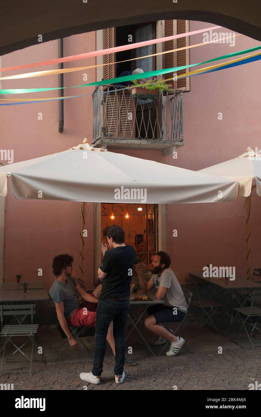 Cuneo Piedmont, Northern Italy young Italian men sitting chatting outside a bar cafe after work, an apparent casual lifestyle.  2019 HOMER SYKES Stock Photo