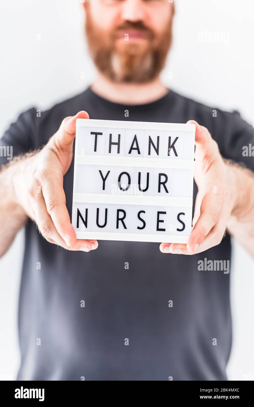 Nurse day concept. Man hands holding lightbox with text Thank your nurses thanking doctors, nurses and medical staff working in hospitals during coron Stock Photo