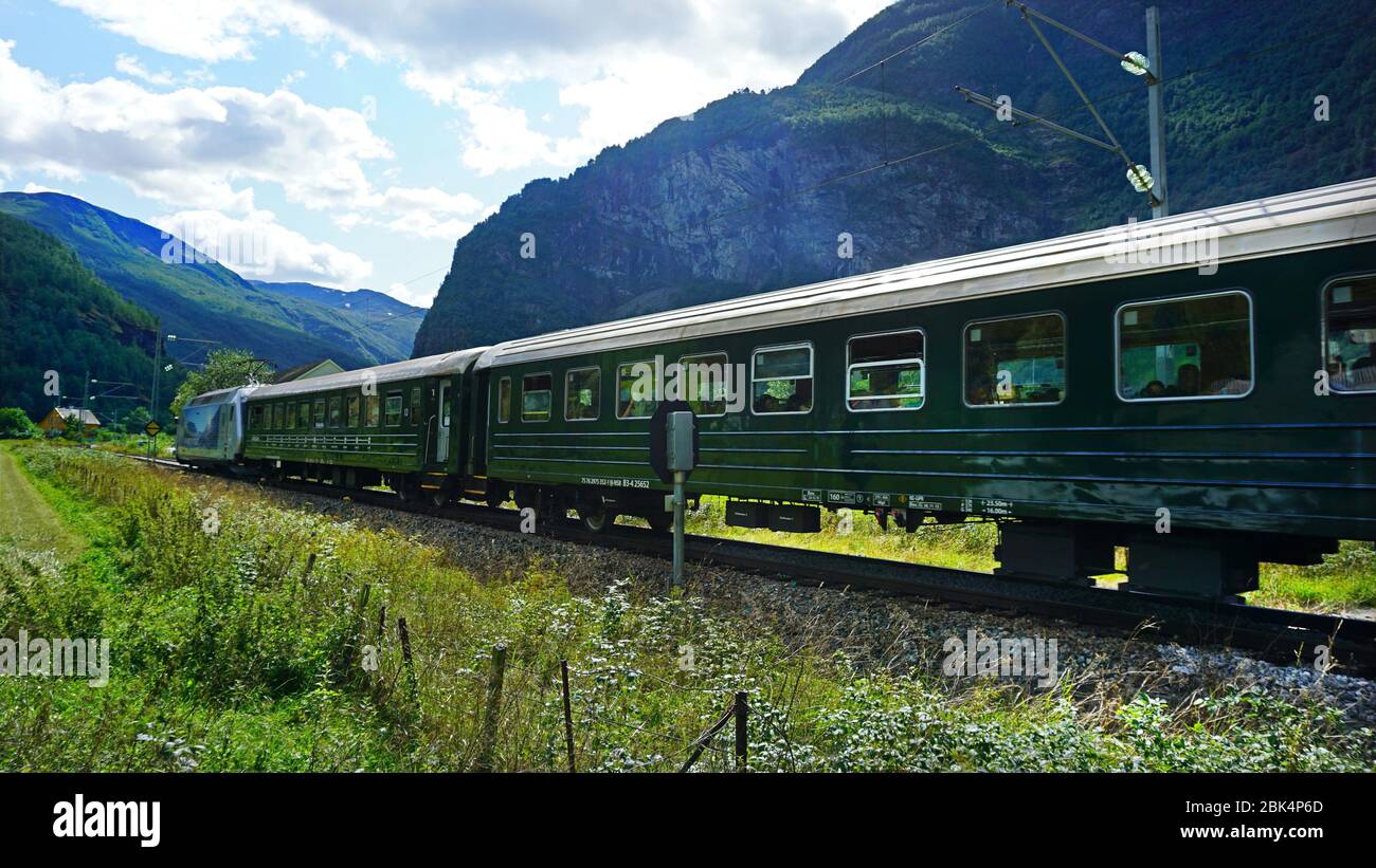 A train (Flåmsbana) passing through the Norwegian village of Flåm Stock Photo