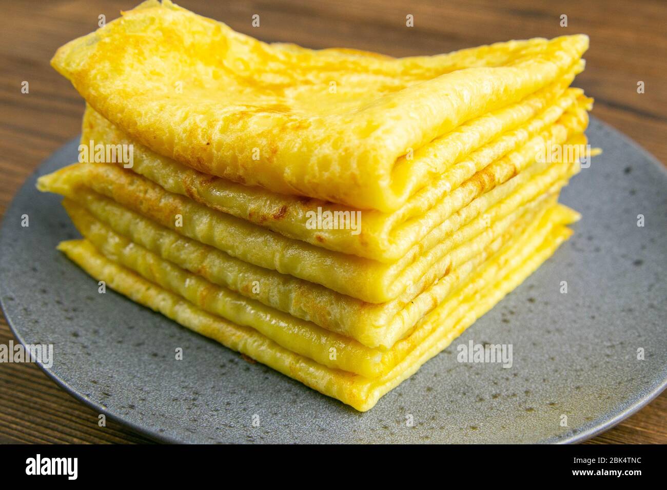 Pancake in gray plate on wooden table. Top views, close-up Stock Photo