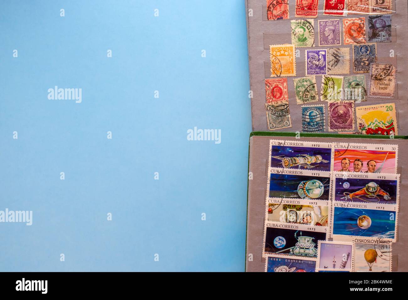 A collection of post stamps in two post albums on blue background. Top view. Stamps collecting hobby. Stock Photo