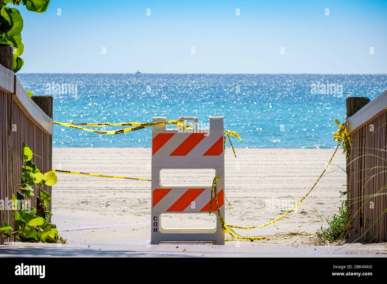 Barricade and caution tape blocking access to Hollywood beach, closed due to COVID-19 - Hollywood, Florida, USA Stock Photo