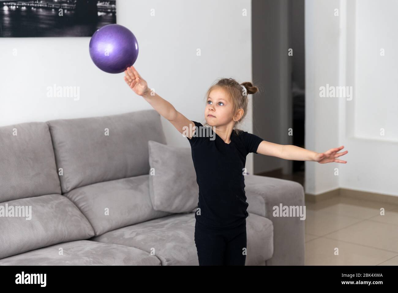 Little girl gymnast, performs various gymnastic and fitness exercises. The concept of childhood and sport Stock Photo