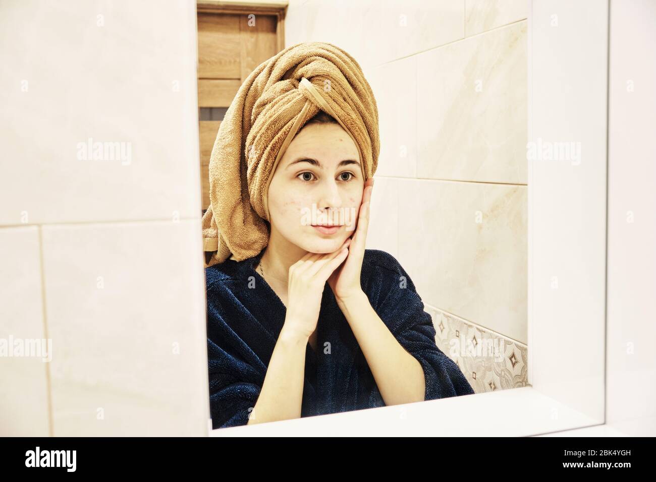 young millennial performs cosmetic procedures in front of a mirror Stock Photo