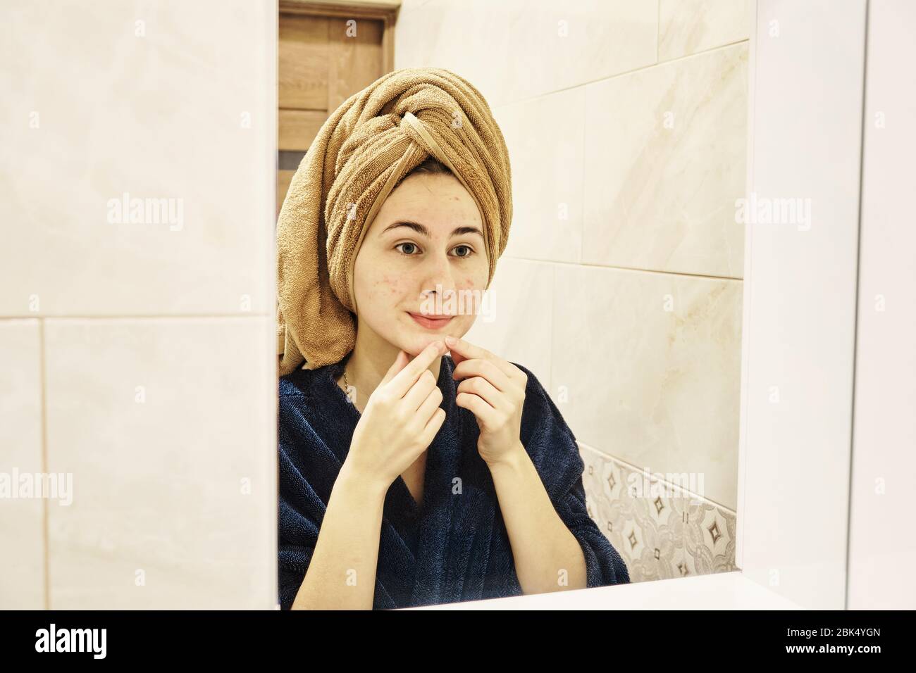 young millennial performs cosmetic procedures in front of a mirror Stock Photo