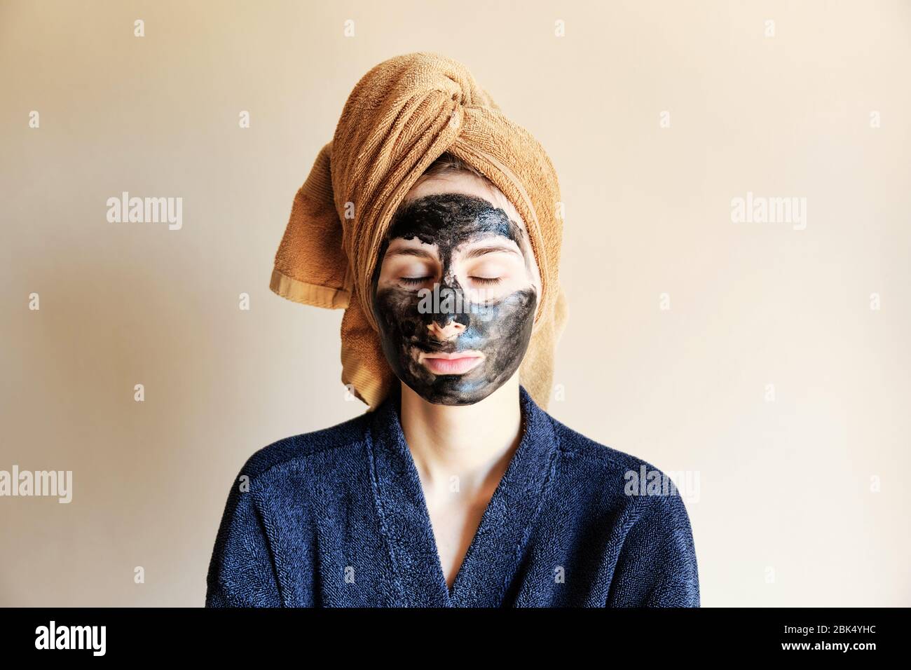 millennial put a black mask on her face and tied a towel on head Stock Photo