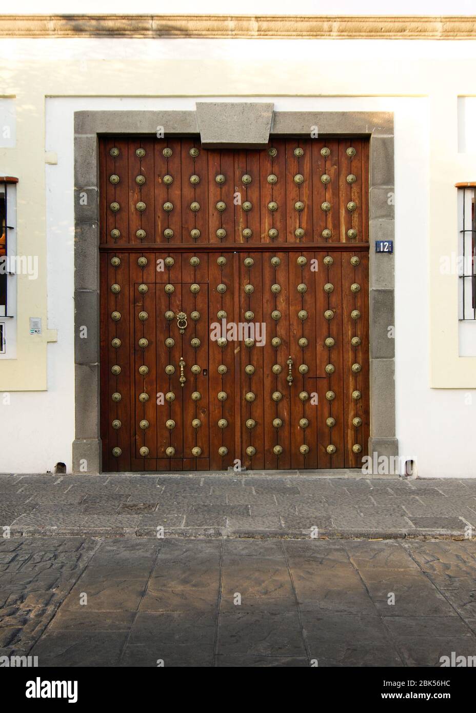 Puebla City, Puebla, Mexico - 2019: View of a wooden door with bronze decorations, an example of the traditional style of this city. Stock Photo