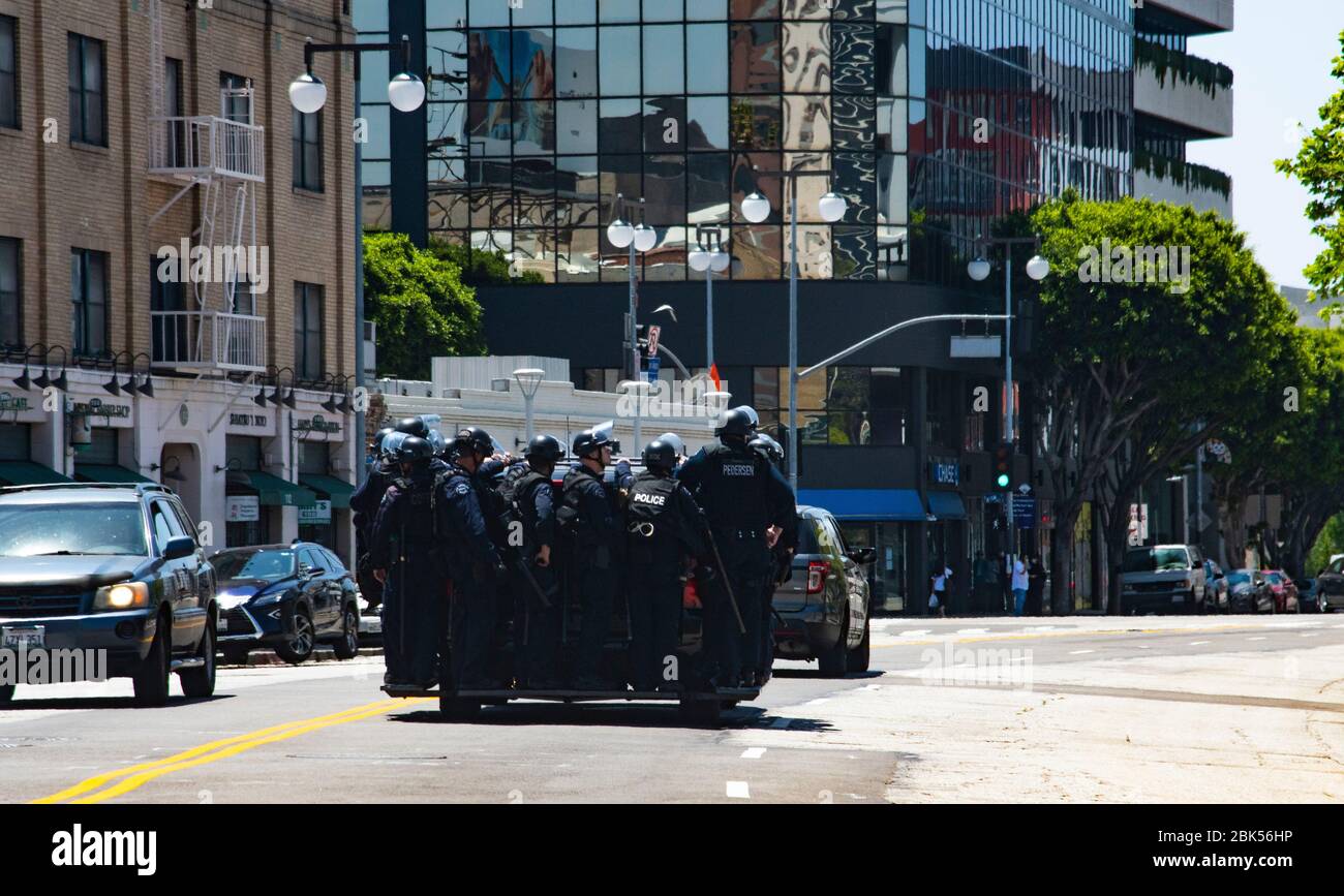 Police swat team preparing for civil unrest ride in police vehicle during a Black Lives Matter protest in Los Angeles during the Coronavirus outbreak Stock Photo