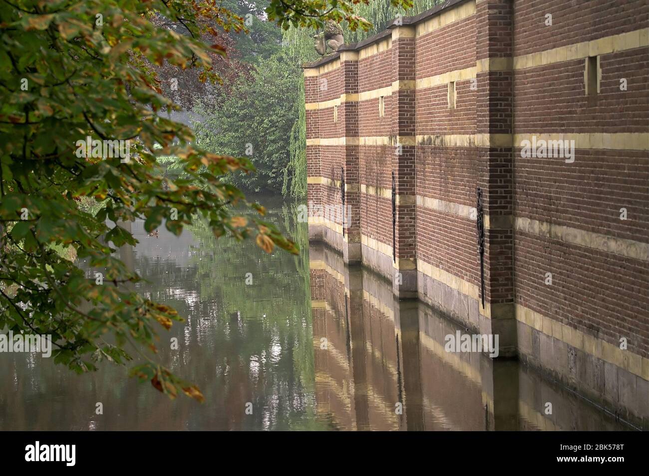 A brick wall rising above the moat. Eine Mauer erhebt sich über dem Wassergraben. Ceglany mur wznoszący sie nad fosą. 上昇在護城河上的磚牆。 Stock Photo