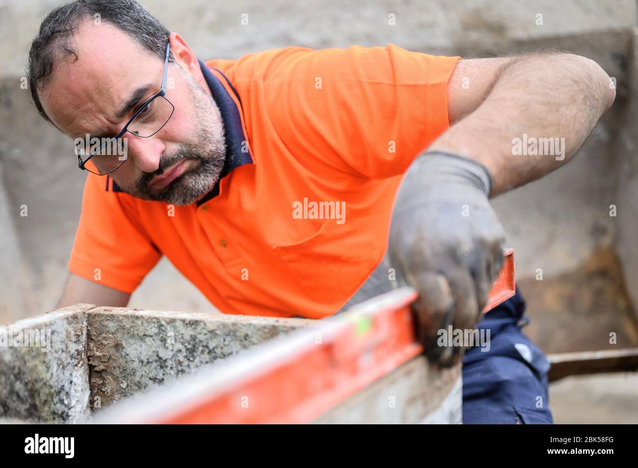 Construction worker checking the bubble level while working at construction site. Building construction . Stock Photo