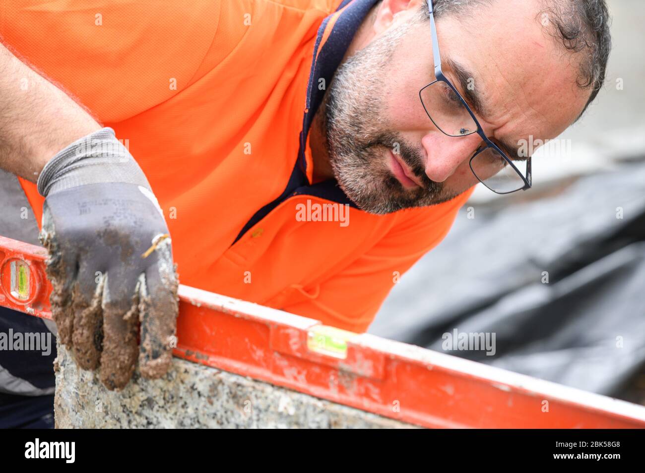Construction worker checking the bubble level while working at construction site. Building construction . Stock Photo