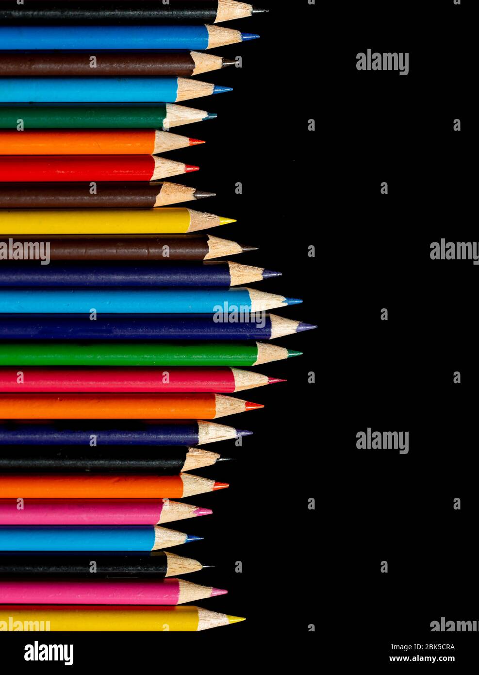 Multi colour pencils arranged on a black background. Copy space Stock Photo