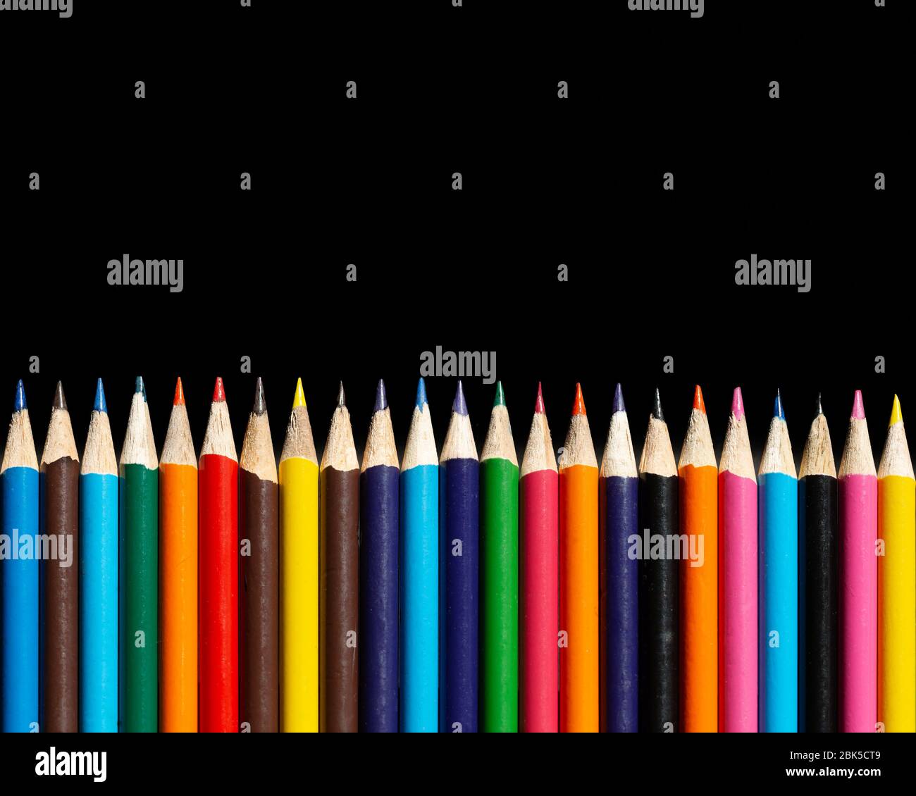 Multi colour pencils arranged on a black background. Copy space Stock Photo