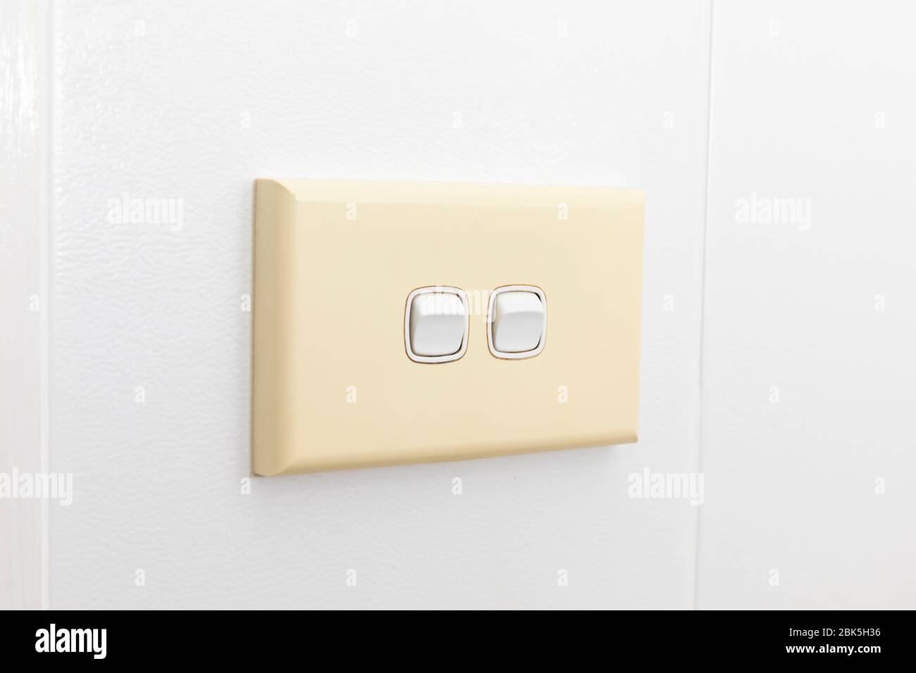 A double light switch on a white tiled wall Stock Photo