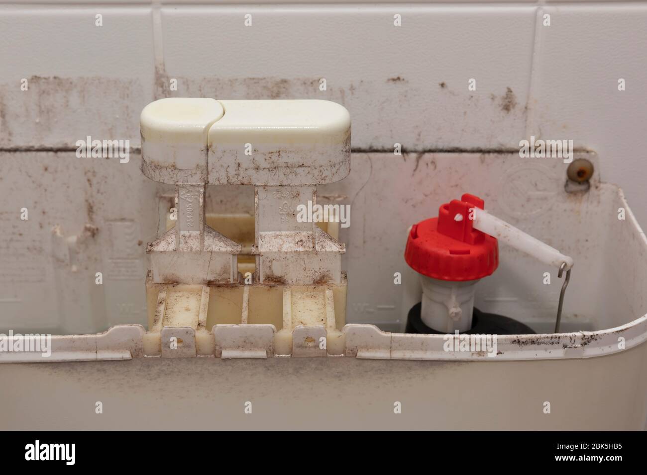 The internal mechanism on an old and dirty toilet cistern Stock Photo