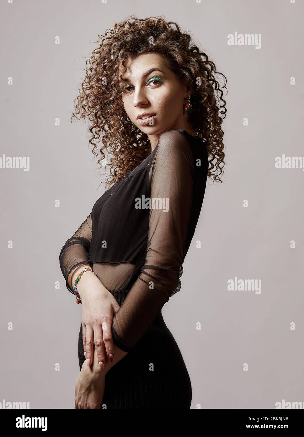 Happy mixed race girl with curly hair is hugging herself Stock Photo - Alamy