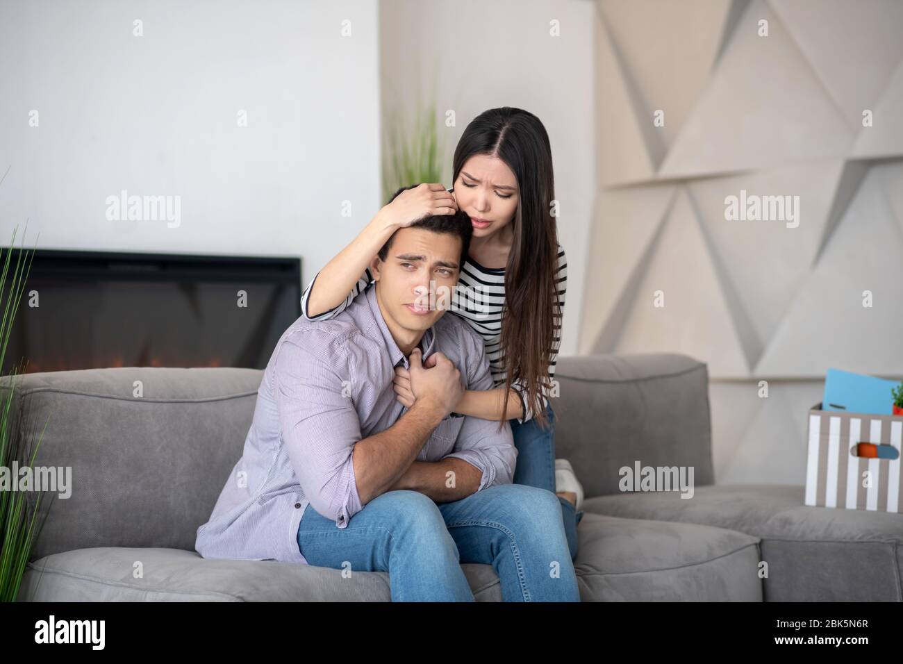 Unhappy lost man and understanding pretty wife. Stock Photo