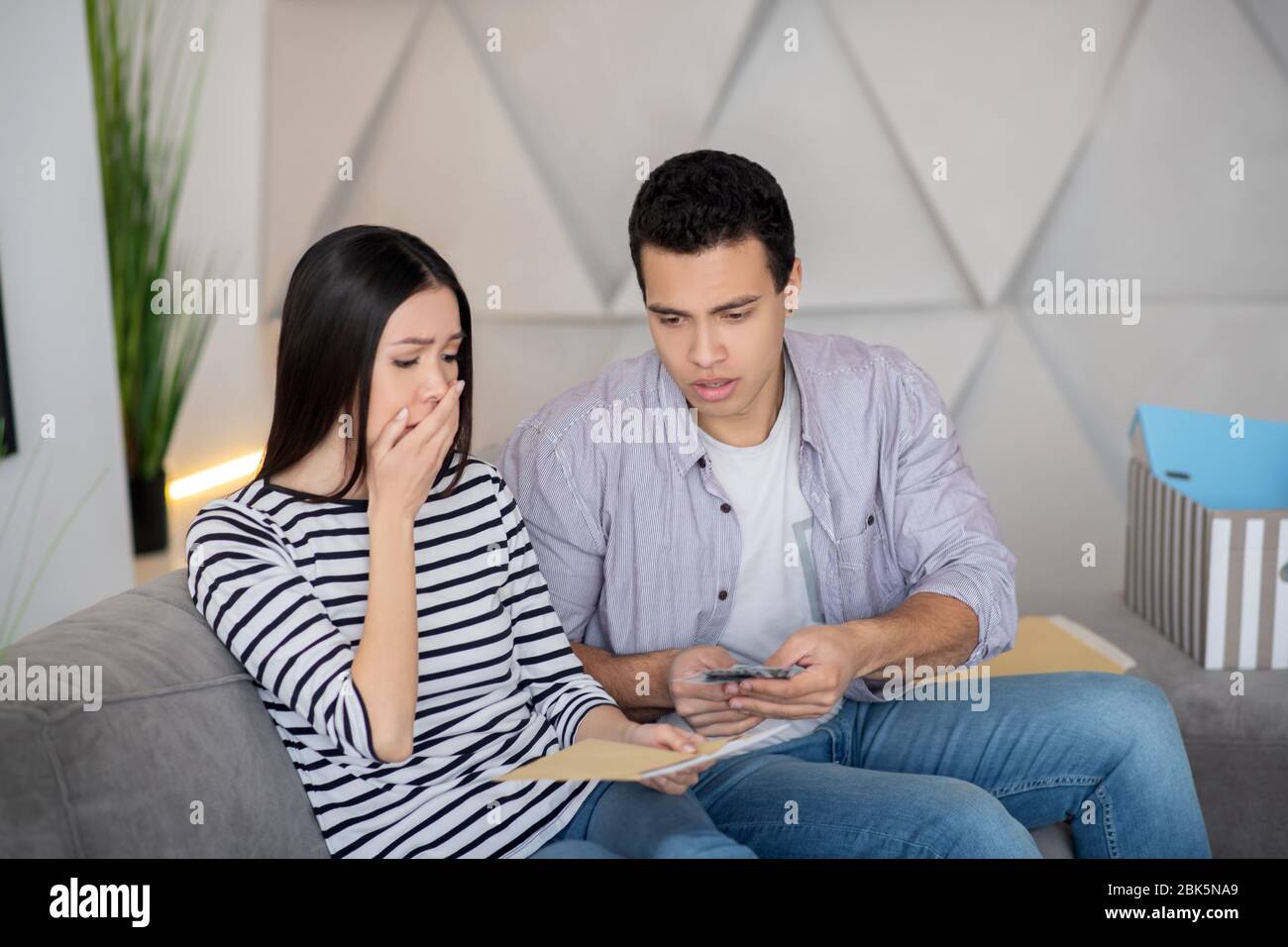 Dismissed from work and received little money husband and upset wife. Stock Photo