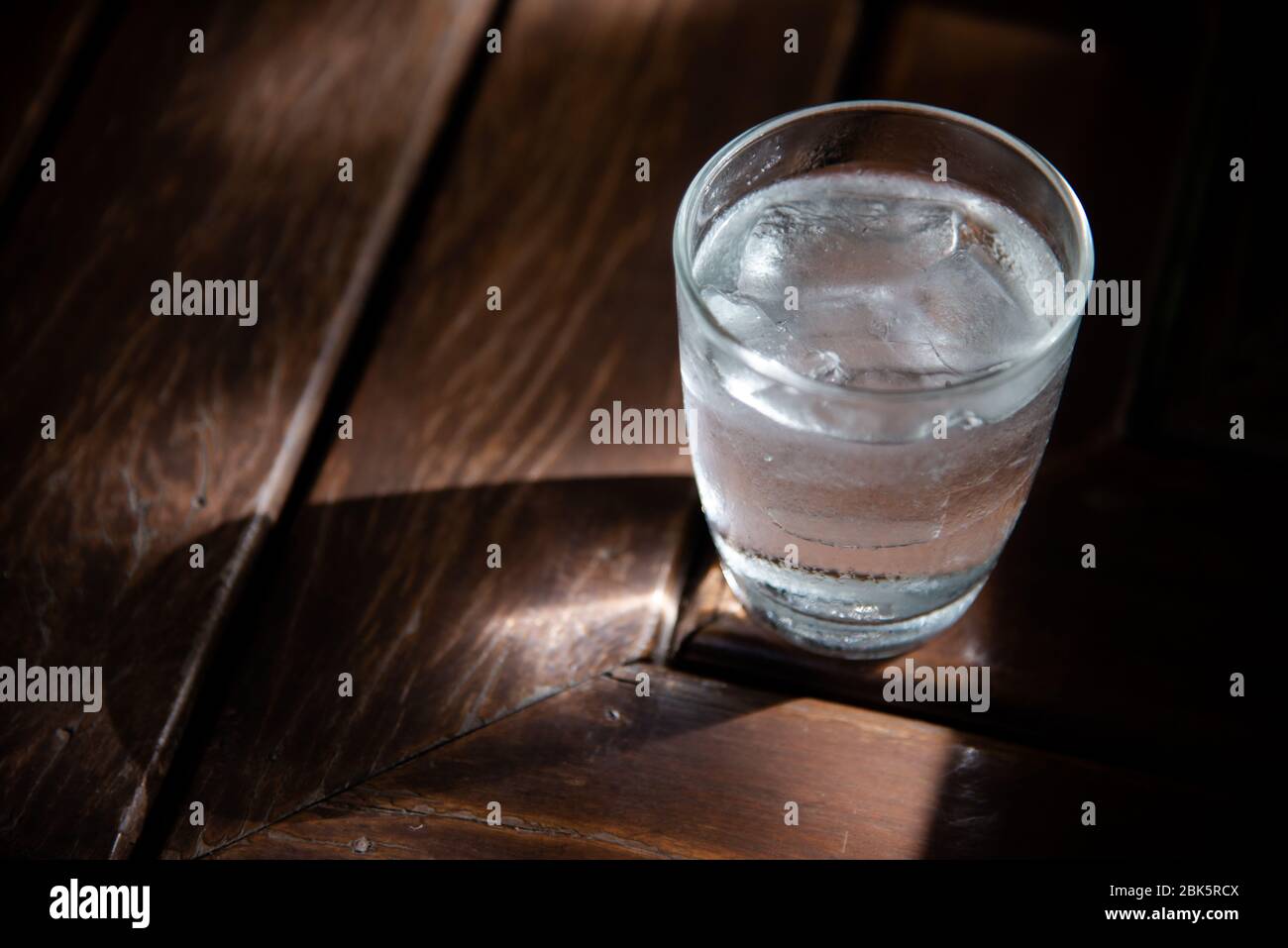 Glass of water on wooden table outdoors Stock Photo - Alamy
